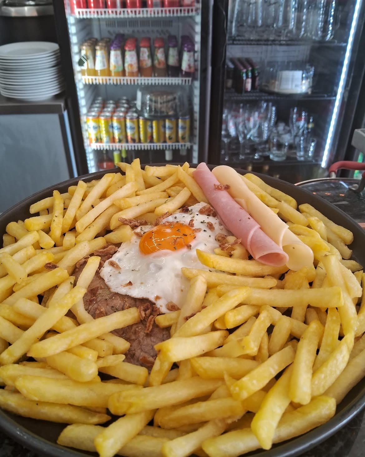 Bife Capa Negra grelhado com ovo estrelado, rodeado de batata frita
