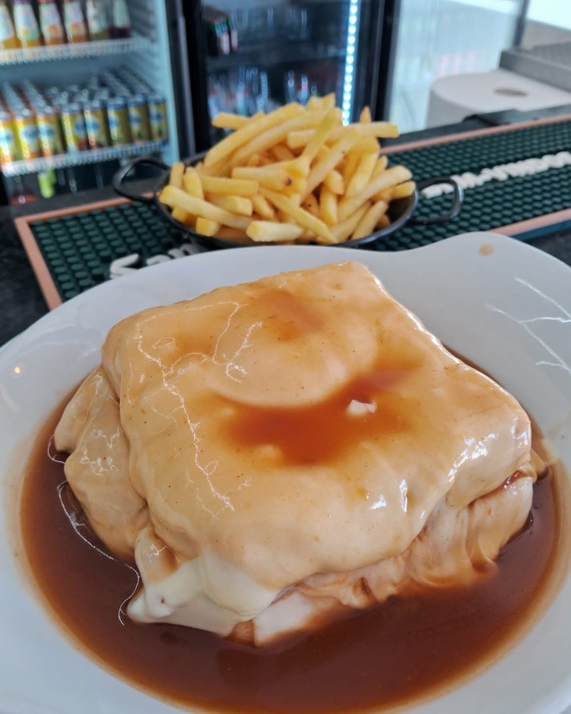 Francesinha do Capa Negra servida com uma taça de batata frita ao lado