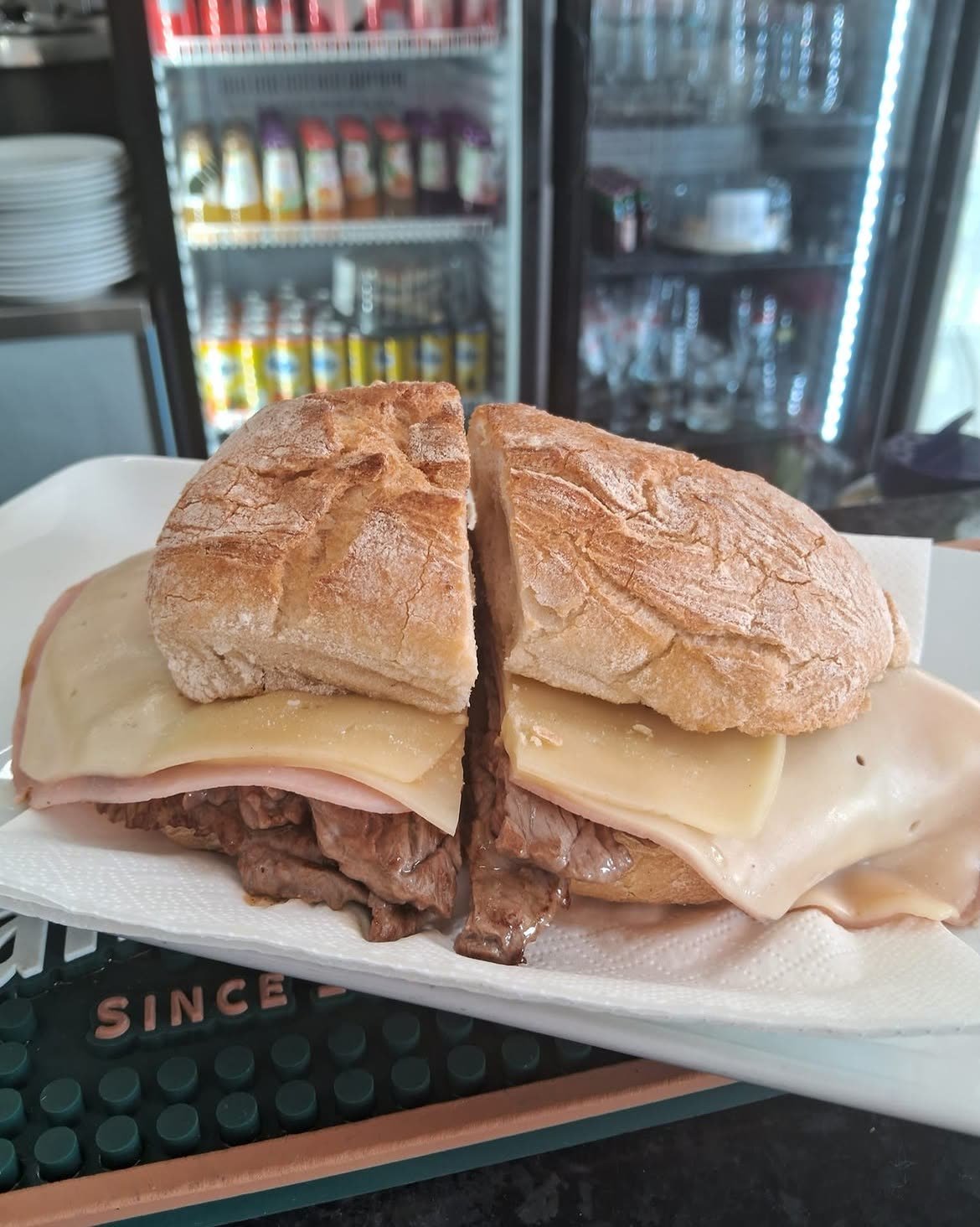 Prego misto em pão de água, aberto ao meio, com bife, queijo e presunto
